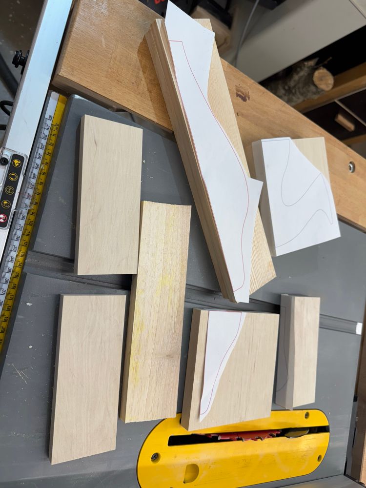 Several pieces of formatted wood from ash, hornbeam and apple tree, partially with patterns glued on them. 