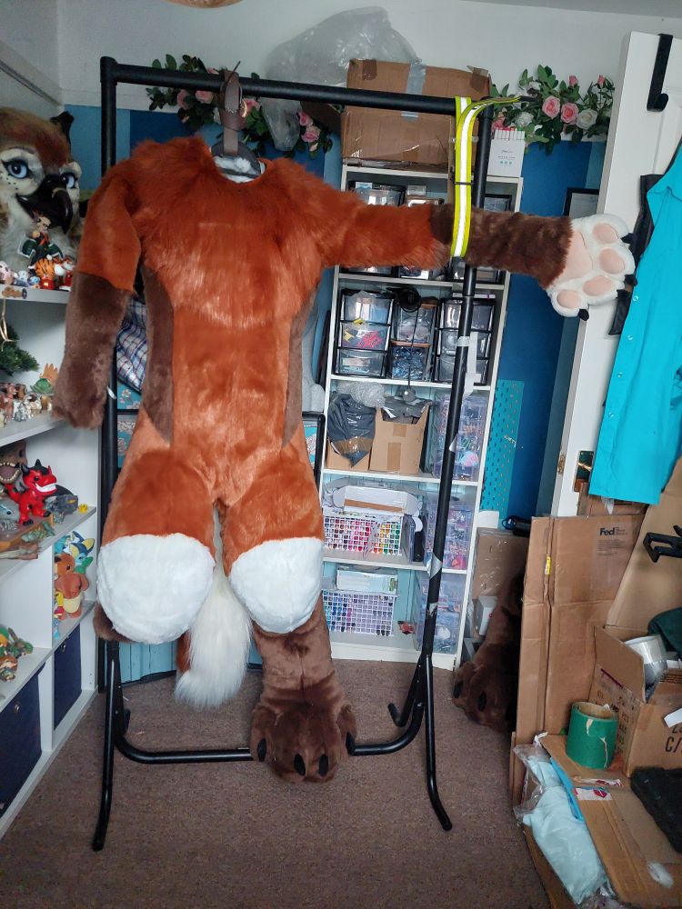 Rust, chocolate and ivory digitigrade bodysuit on a dtd rack