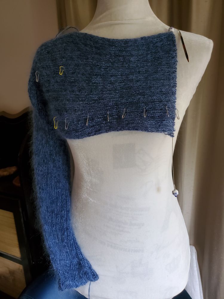blue fuzzy knit shrug wip, still missing 1 arm on white dressform #knitsky
yarn is 1 ply douceur et soie, 2 strands merino due