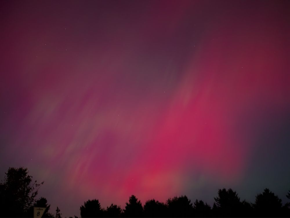 My sister in law sent this series of 4 photos of the auroras dancing over Lanark, Ontario in Canada. “The skies are just so PINK!” she said; and also “they’re really dancing tonight”. This one is all magenta streaked with slight greens dancing over the sky in wide swaths.