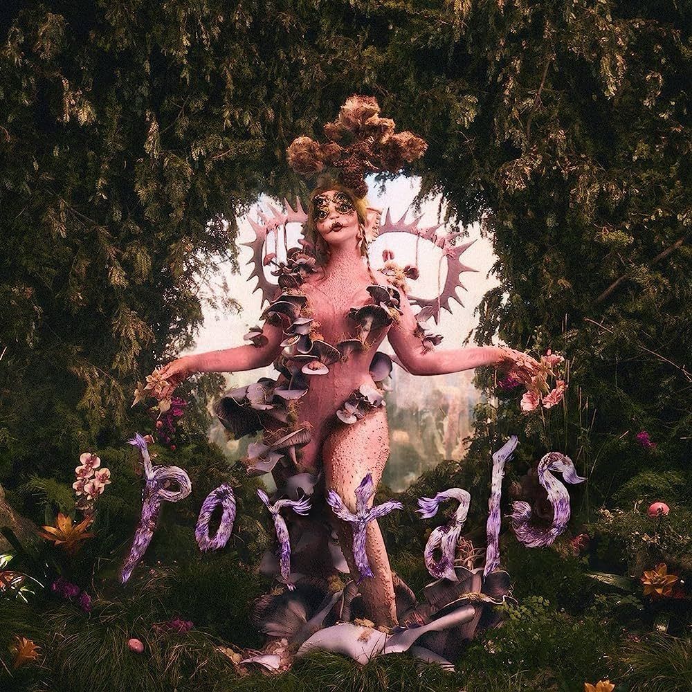The cover to Melanie Martinez’s album Portals, which takes place in a forest and features a weird giant pink creature in the front 