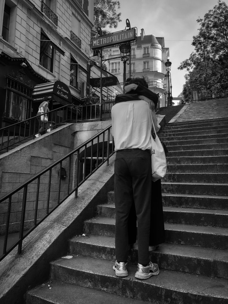 Couple s'enlaçant sur les marches de la rue Pierre Dac, au-dessus de la station Lamarck - Caulaincourt dans le 18e arrondissement de Paris, le 17 mai 2020.