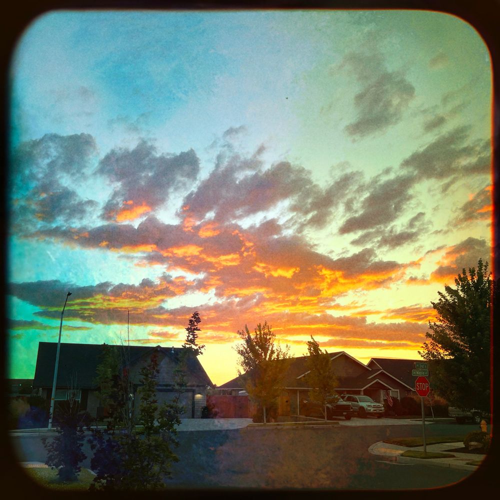 Bright orange and red clouds above some houses.