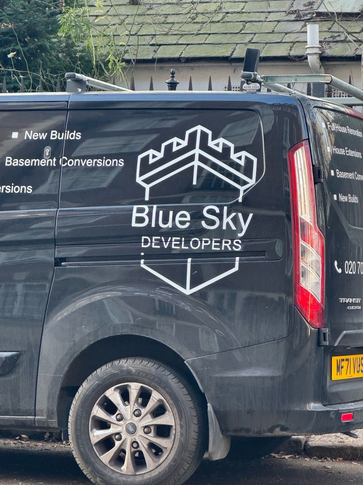 Van with the writing “Blue Sky Developers” advertising building services and basement conversions 
