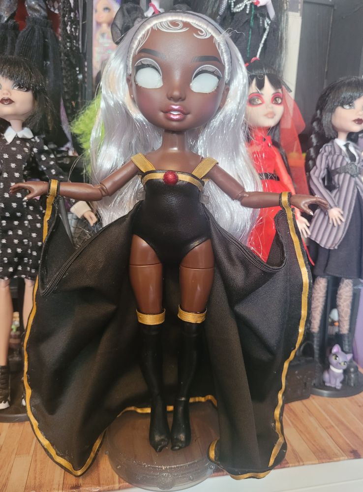 Rainbow high Ayesha Sterling Doll turned into Custom X-Men Storm. Wearing a black leotard with black thigh highs and cape, trimmed with gold ribbon.