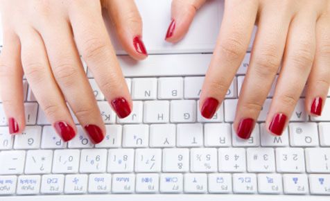 A pair of hands with red nails typing on a white keyboard, this image is also the Kadin Yazilimci ‘s logo.