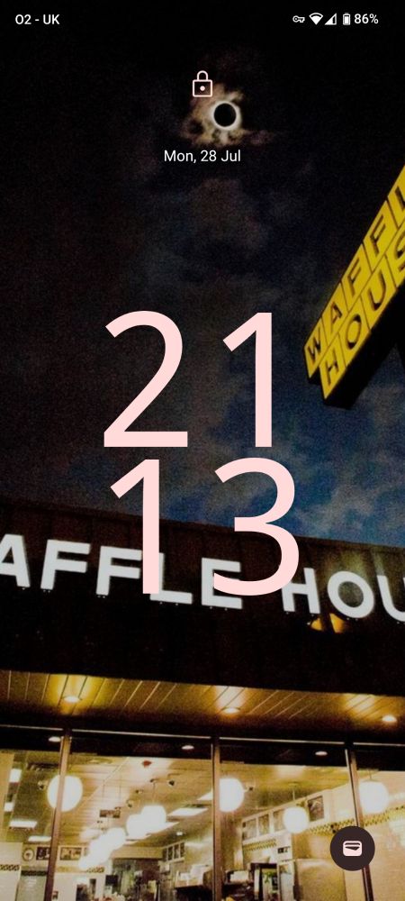 My phone's lockscreen - a photo depicting a Waffle House underneath a total solar eclipse.