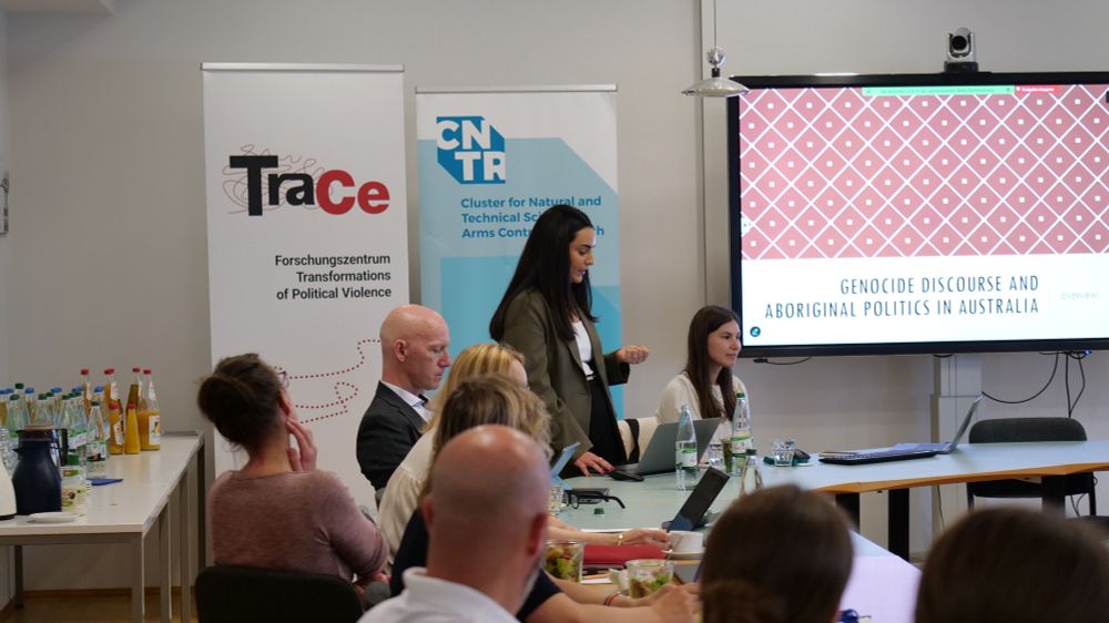 Over the heads of the audience, you can see Sally Ghattas standing and speaking. In the background is her presentation projected on a screen on the wall.
