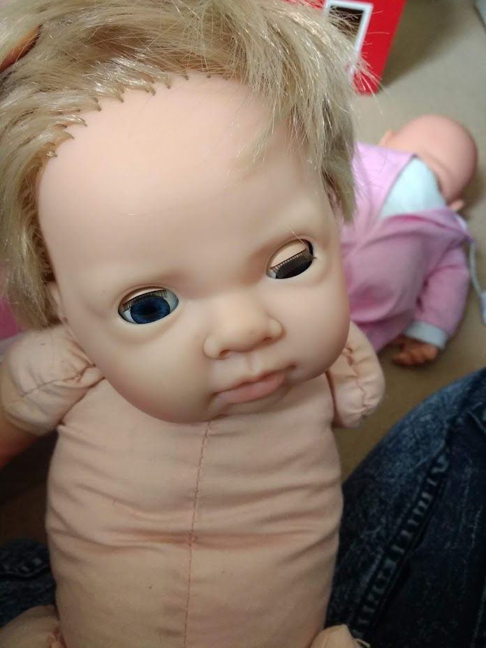 A fairly wonky looking doll. It has one eye half-shut and looks ... frowny