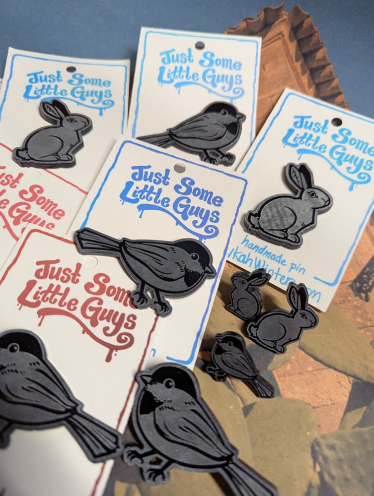 Chickadee and rabbit acrylic pins. Backings read "Just Some Little Guys/ handmade pin / RivkahWinter.com"