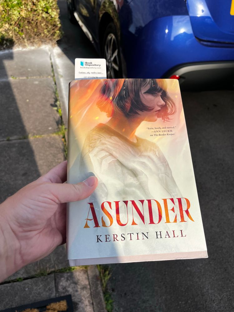 A copy of Kerstin Hall’s book Asunder, in hardback. Photo taken in the sun, cos its too hot to be inside.  