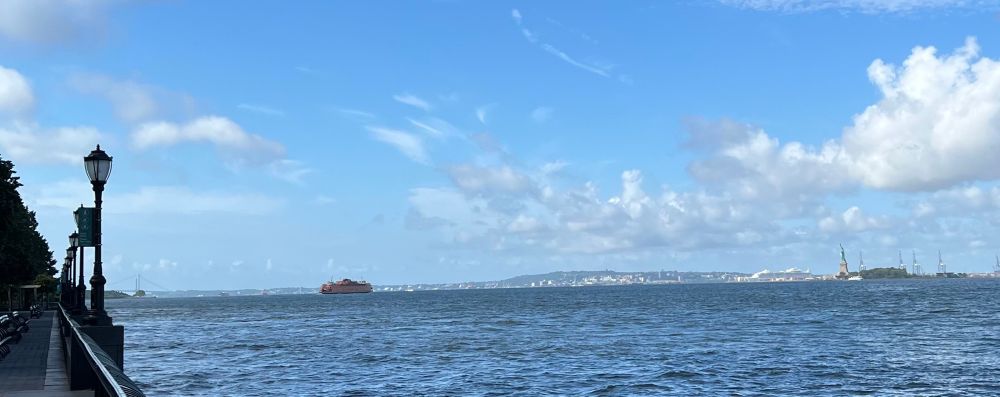 Hudson River flows into NY harbor, Staten Island Ferry, Lady Liberty in distance, pretty blue skies. 