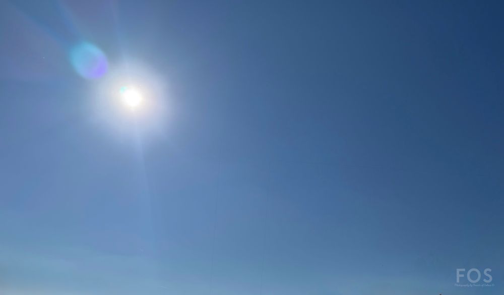 The sun shines brightly in the blue sky. 