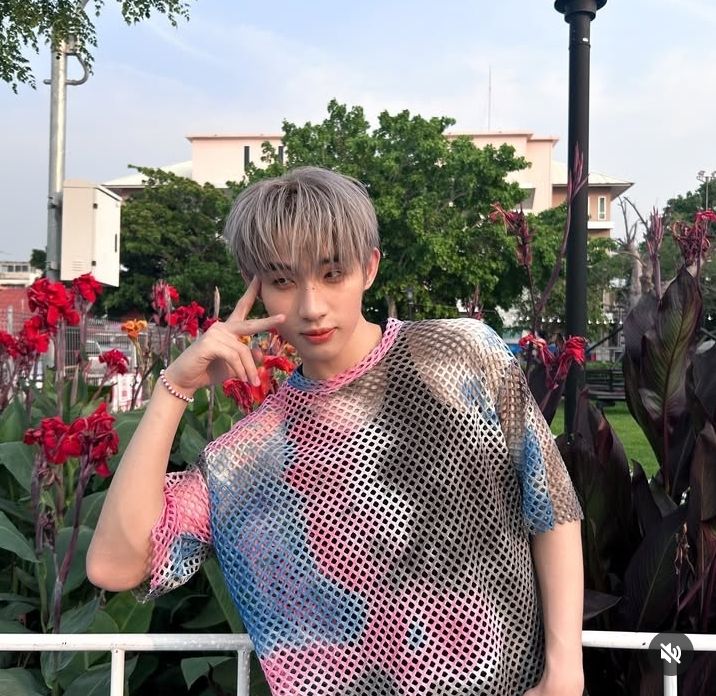 Foto do Hong do grupo LYKN. Ele está com uma blusa tie die colorida