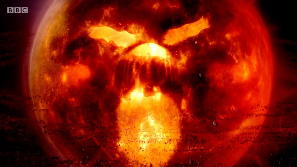 Screen capture from Doctor Who: The Rings of Akhaten, showing Akhaten, a burning, planet-like entity with brighter patches resembling eyes, nose and mouth.
