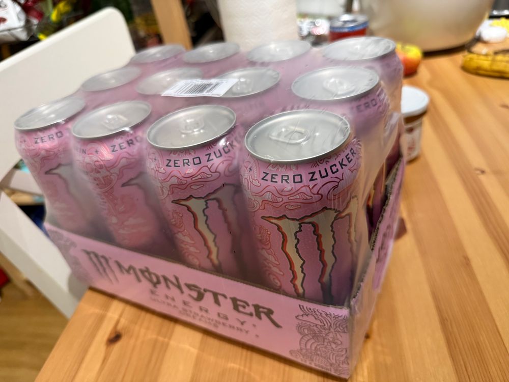 Eine 12er Packung Monster Energy Strawberry auf einem Holztisch 