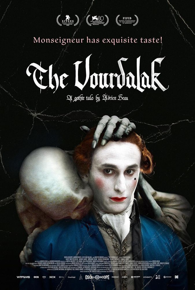 Movie poster for The Vourdalak. The bust 18th century French nobleman looks forward, with a lead white face, red lips, and over rouged cheeks stares forward on a black background. Behind him a skeletal ghoul grabs onto his hair and shoulder bites down on the base of his neck. The movie title appears in white gothic font. 