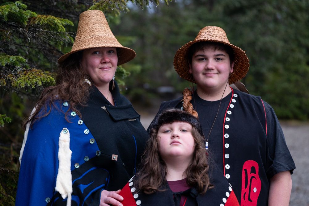 Heather Evoy and her children, Silje and Judah Haven Marr, in regalia with the forest in the background. Photo by Andrés Javier Camacho.
