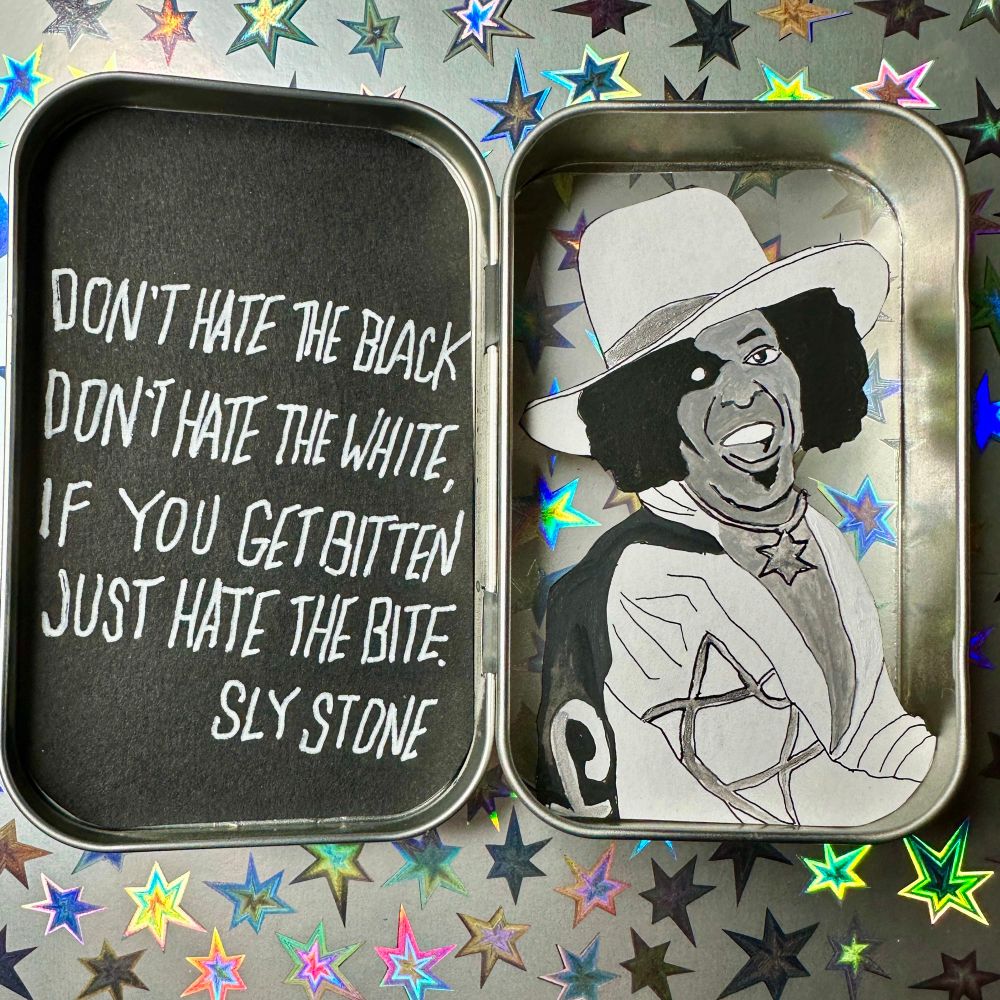 Cut paper diorama of sly stone in an Altoids tin 
