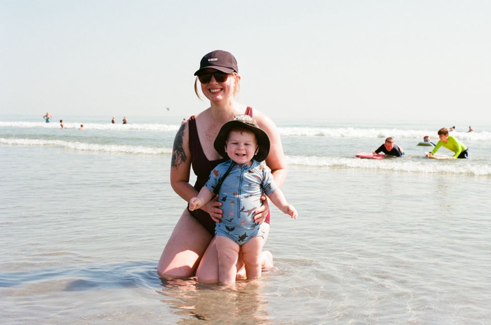Mother and son posing for a photo on the beach.