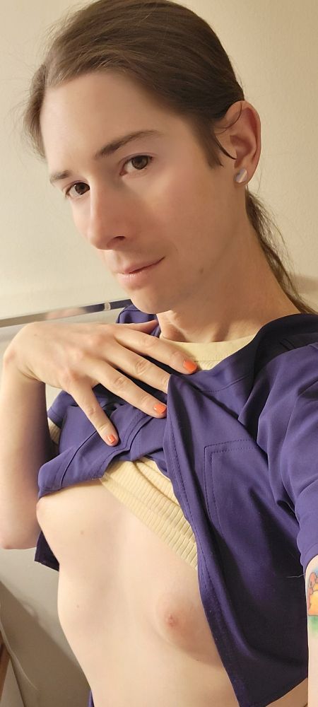 Selfie of Bria wearing scrubs with the top pulled up