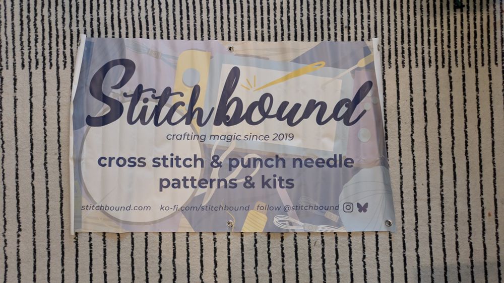 a vinyl banner with information about stitch bound that has many vertical creases. it's subtle in the light, but it almost looks like it was accordion folded