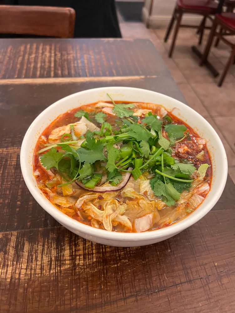 a spicy bowl of Bún bò Huế, cilantro on top. 