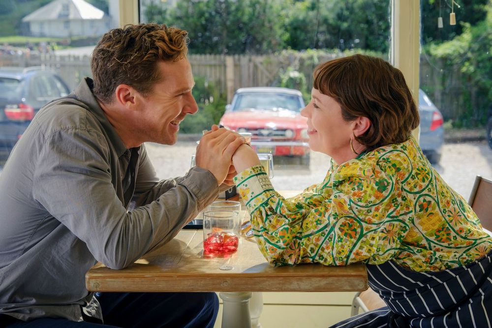 Benedict Cumberbatch and Olivia Coleman holding hands and gazing lovingly at each other in The Roses (2025)