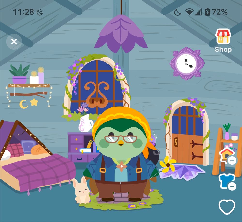 A screenshot from the Finch app: a green bird with a dark blue shirt, brown paints, and a yellow bandana is standing in a blue room with purple items and fixtures.