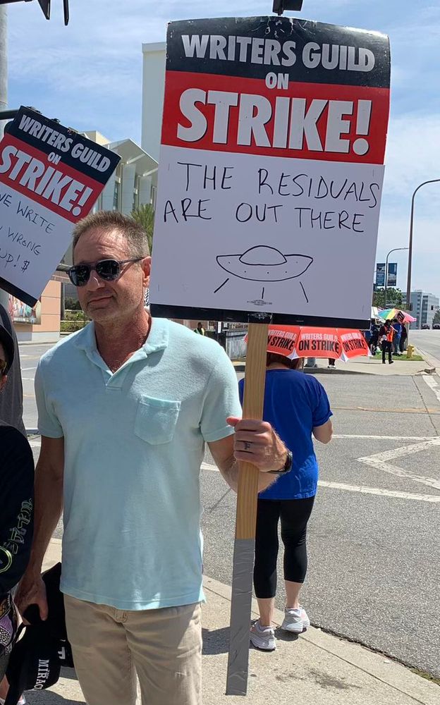 David Duchovny on the picket line holding a sign that says Writers Guild on Strike! The residuals are out there.