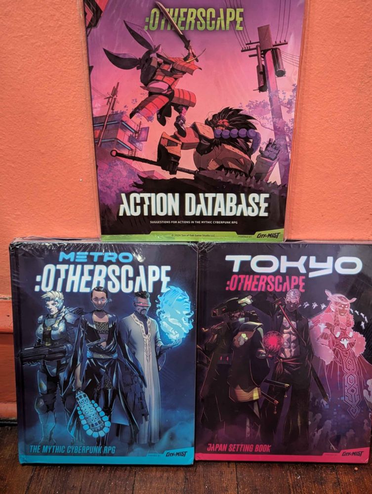 The books Metro:Otherscape, Tokyo:Otherscape, and :Otherscape Action Database stacked on top of eachother