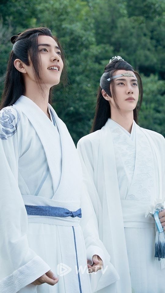 Closeup of Wei Wuxian (actor Xiao Zhan) and Lan Wangji (actor Wang Yibo) standing side by site in white robes