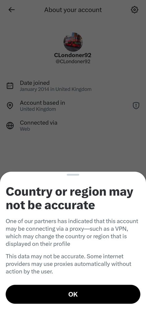 A screenshot of a social media account settings page. It shows the username “CLondoner92” with a profile picture featuring a red London bus. The page displays the date the account was created, the country the account is based in, and the connection method. At the bottom, a pop-up message states that the country or region may not be accurate because the account might appear to be using a proxy or VPN, and that some internet providers use proxies automatically. An “OK” button is shown beneath the message.