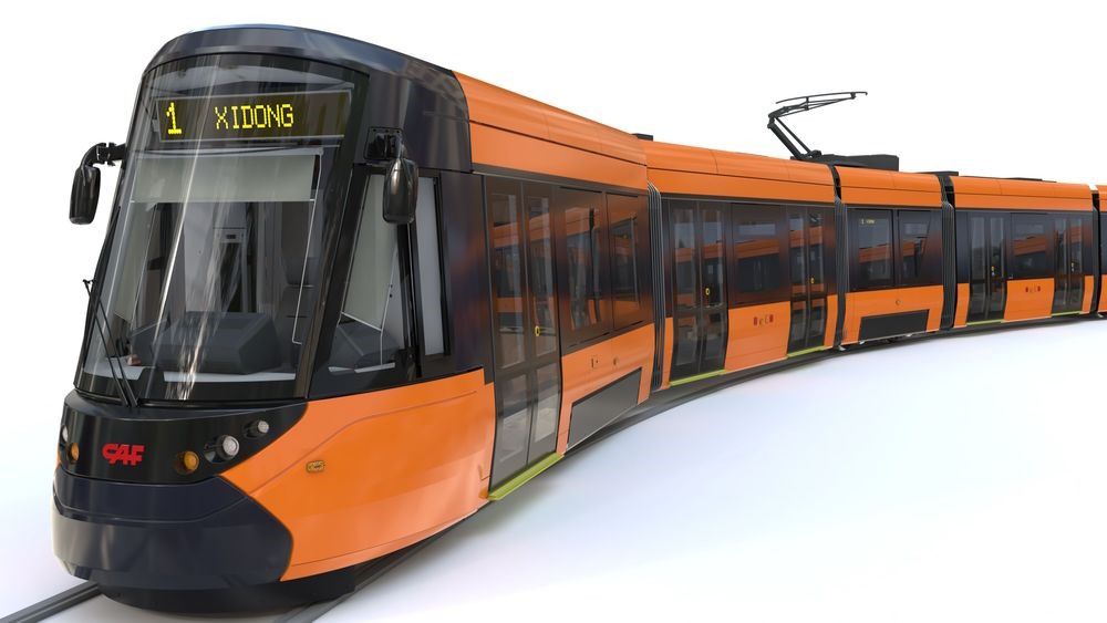 The image shows a modern tram with a sleek, curved design. The front of the tram features a large windscreen with various reflective surfaces. The body of the tram is painted in bright orange with black accents. It is segmented into multiple connected carriages, visible in the image as it takes a gentle curve along the track. The side windows are tinted, and there are overhead power lines connected to the top of the tram. The logo "CAF" is displayed on the front.