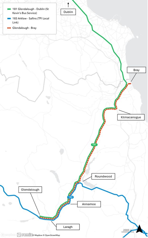 The image is a map highlighting bus routes in a region. Three routes are distinguished by color: the green line represents the 181 Glendalough-Dublin (St. Kevin's Bus Service), the blue line represents the 183 Arklow-Sallins (TFI Local Link), and the dotted red line represents the Glendalough-Bray route. Key locations labeled on the map are Dublin, Bray, Kilmacanogue, Roundwood, Annamoe, Laragh, and Glendalough. The routes intersect and diverge, linking these places. The background is a grayscale map detailing the geographic area, roads, and some topographical features.