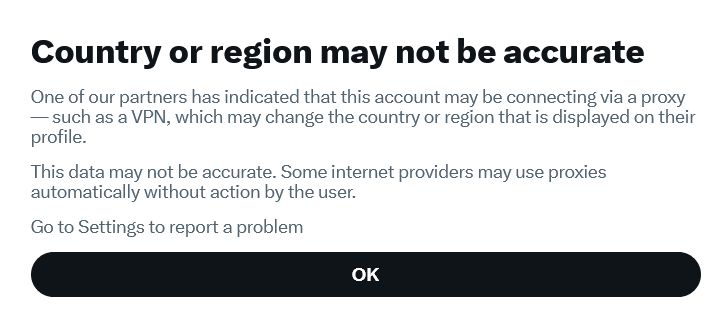 A notification screen with the heading “Country or region may not be accurate”. The message explains that the account may be connecting through a proxy or VPN, which can change the displayed country or region. It notes that the information may be incorrect and that some internet providers use proxies automatically. A link to “Go to Settings to report a problem” appears above a large “OK” button.