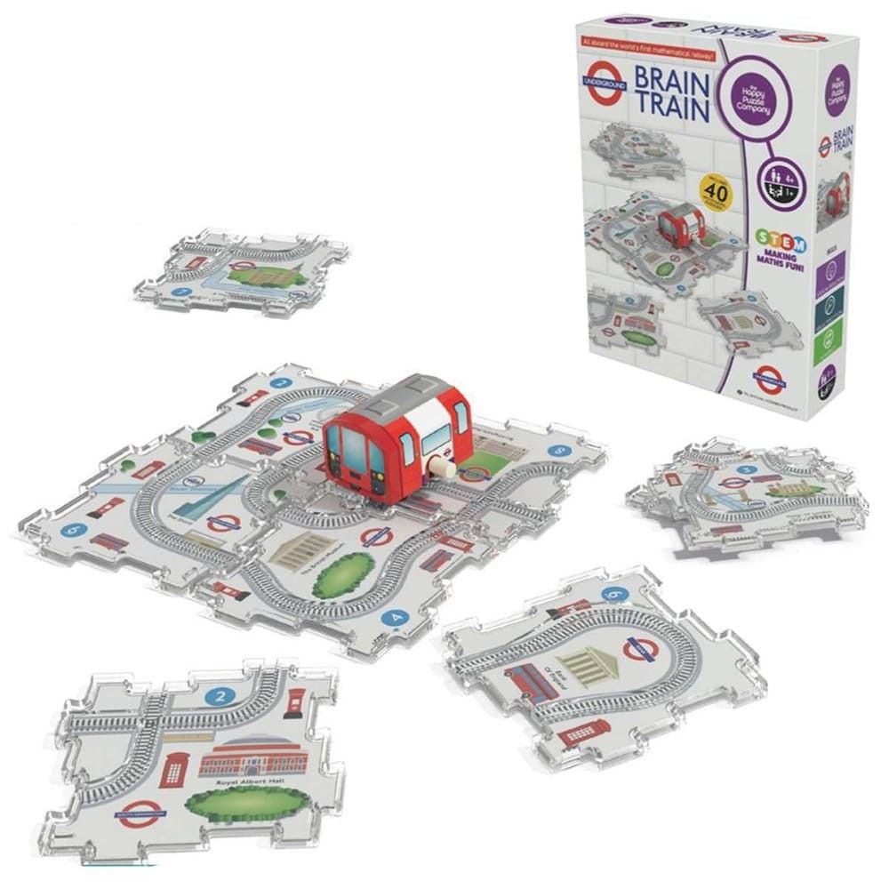 A photograph of the 'Brain Train Game' by The Happy Puzzle Company and London Underground. The game features a small red toy train on a clear plastic track piece forming a central square, surrounded by four other irregularly shaped track pieces showing London landmarks like 'Royal Albert Hall' and 'Bank of England'. The game box, which features the Underground logo and states "40 Puzzles 4 - 84+", is visible in the top right corner.

TfL Image