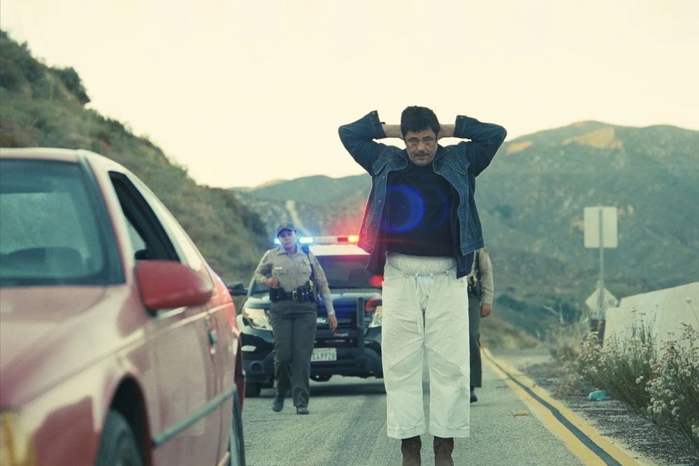 Pulled over by the cops, Benicio del Toro is about to own up to a few small beers in Paul Thomas Anderson’s ONE BATTLE AFTER ANOTHER (2025)