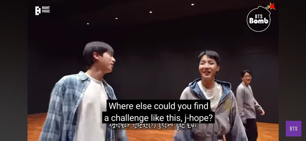 Jin and Hobi in the practice room filming the Running Wild challenge. Jin is saying "where else could you find a challenge like this, j-hope?" as Hobi laughs.