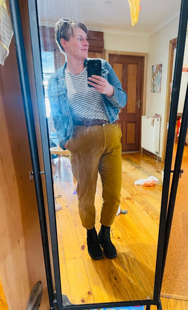 Tan beown high waist pants with black heeled, suede ankle high boots.
On top a striped black tee and cropped denim jacket