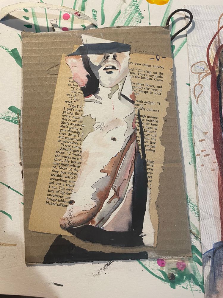 A collage on raw cardboard, a torn out old bookpage and a torn piece of an ink drawing of a male naked torso