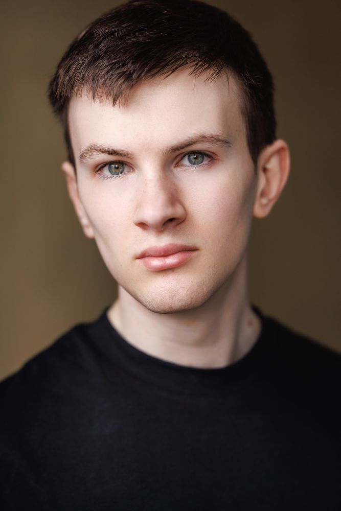 Max with a neutral face, wearing a black t-shirt.