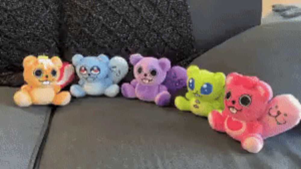 a bunch of stuffed animals are lined up on a couch