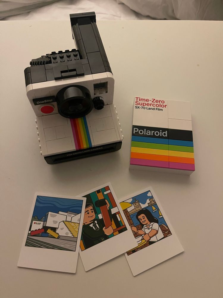 The lego polaroid camera, film box, and three lego polaroid photos. 