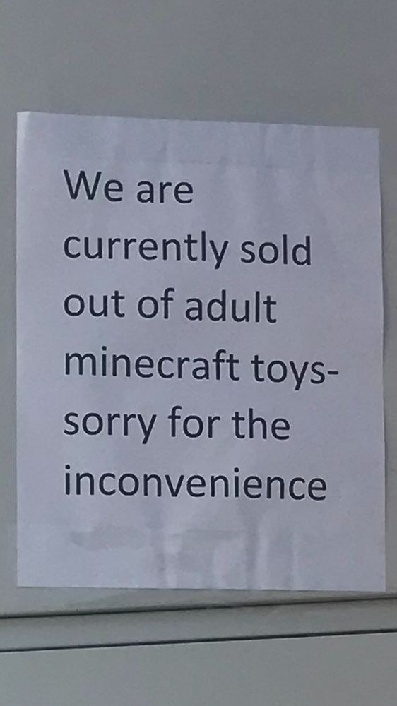 a paper sign reading “We are currently sold out of adult Minecraft toys-sorry for the inconvenience”
