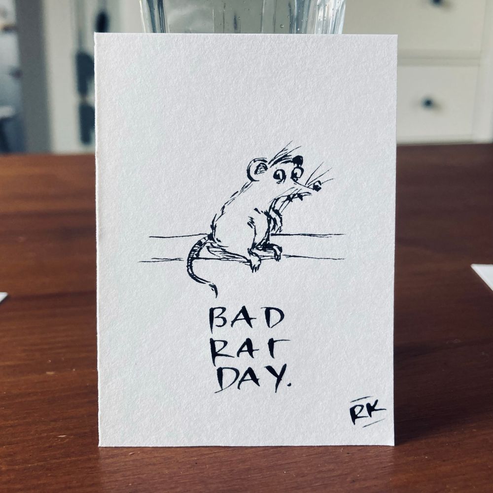 eine mini zeichnung von einer grimmigen ratte mit augen und zähnchen. darunter steht: bad rat day