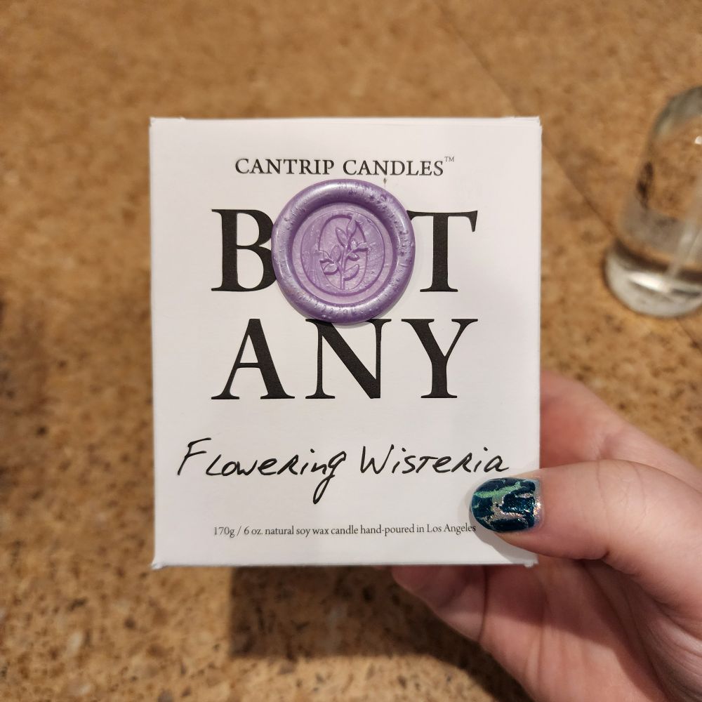 The box of the Botany candles I bought. There's a wax seal that makes the "o" in Botany for the text and, since this is for Flowering Wisteria, the color of the seal is a light purple to match.