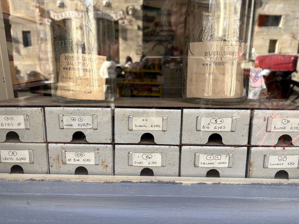 Drawers at a robot-sculpture-art place which are labelled with different kinds of eyes 