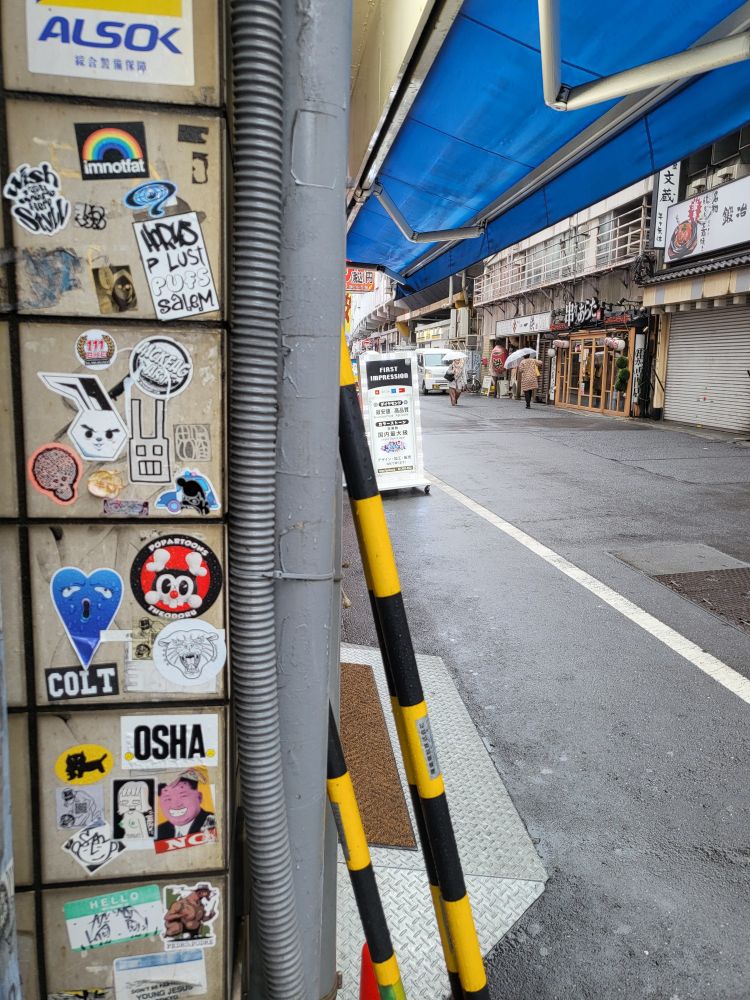 Various little stickers on a corner/ side of a shop: imnotfat, colt, osha etc.