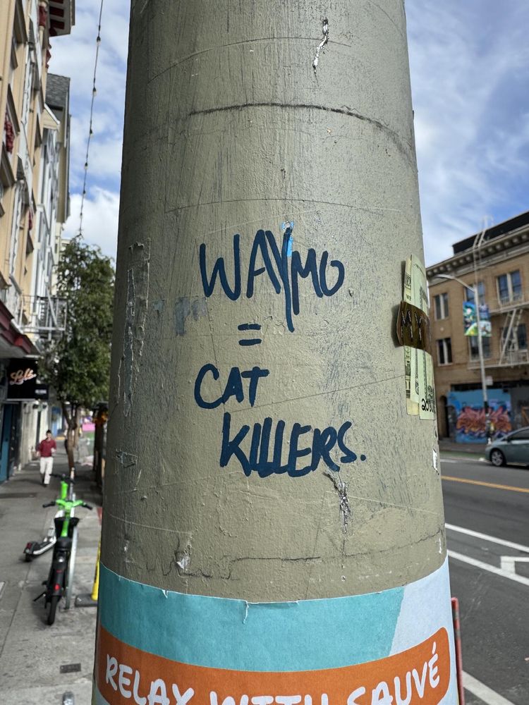 Graffiti that says "Waymo = Cat Killers"